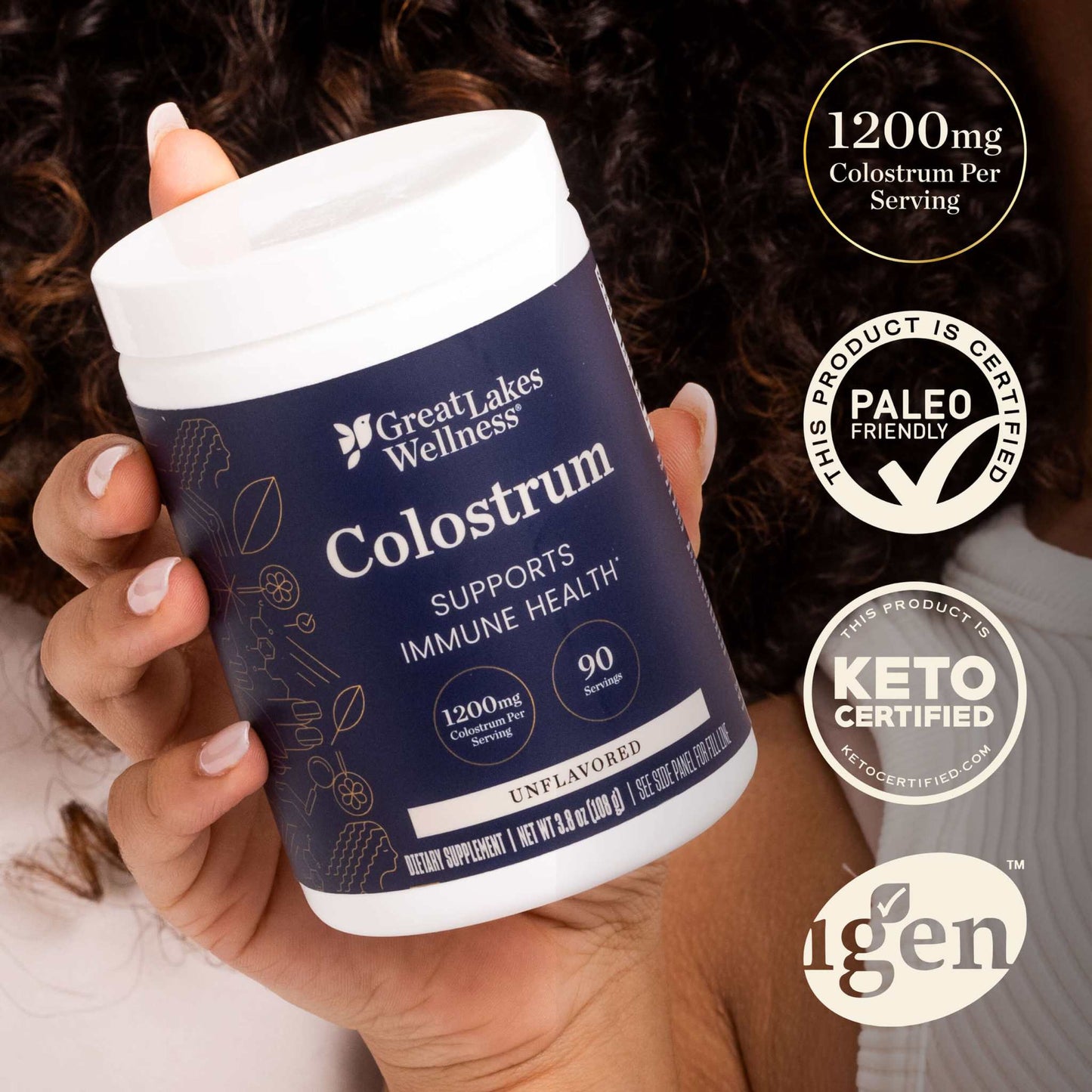 Great Lakes Wellness Colostrum Powder container held in hand, showing 1200 mg per serving, immune support, 90 servings, paleo and keto certified.